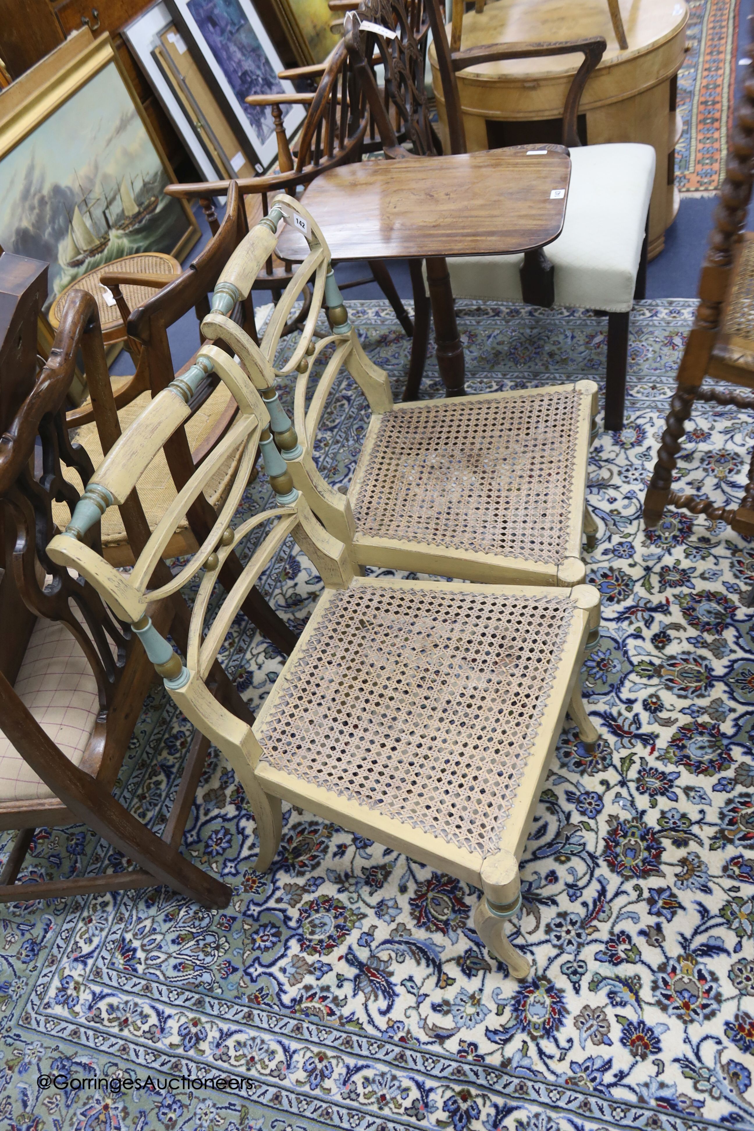 A pair of early 19th century part painted beech single chairs, with cane seats